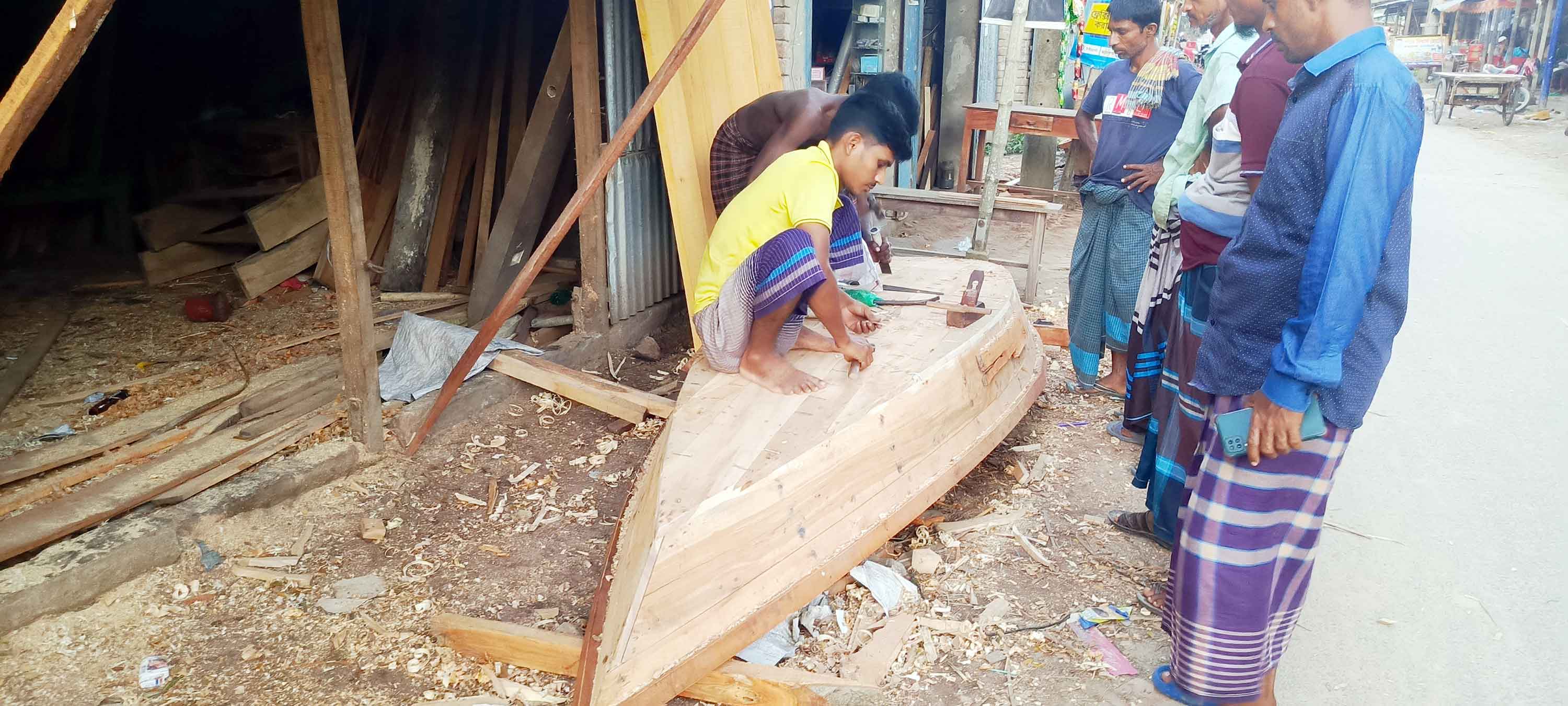 সালথায় ডিঙ্গি নৌকা তৈরিতে ব্যস্ত কারিগর
